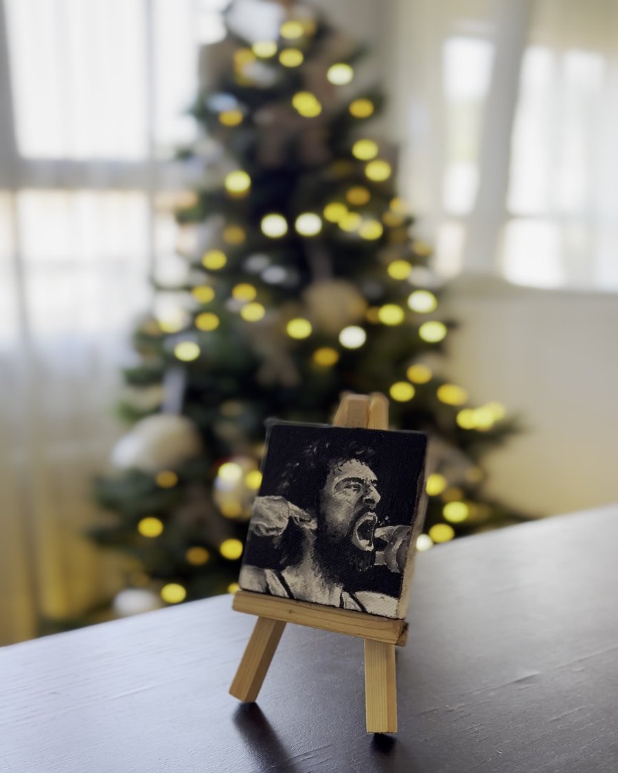 A small finished canvas portrait on a mini easel